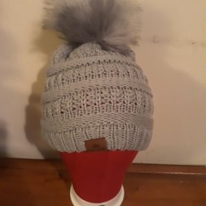 Grey winter hat with furry puff top